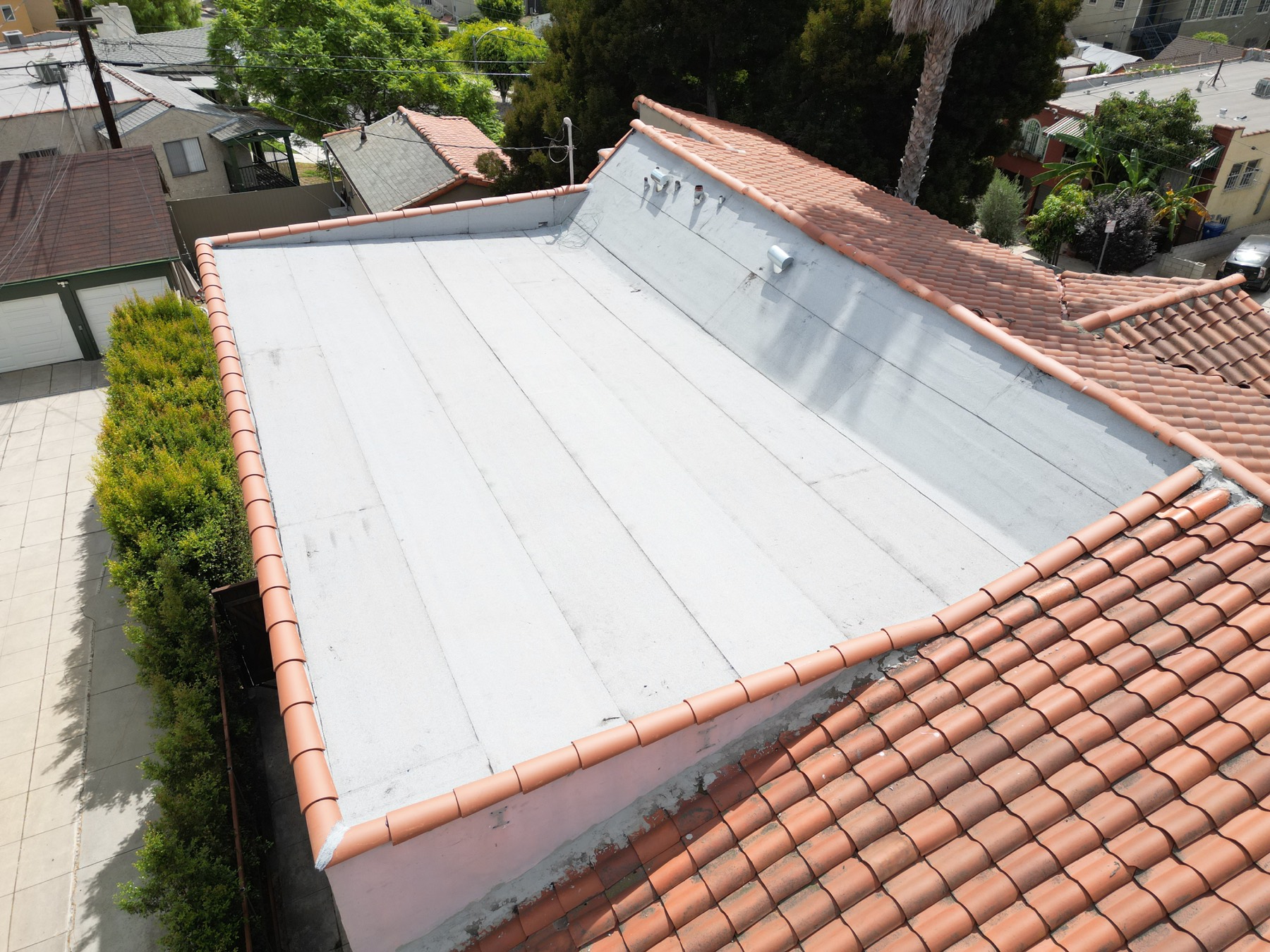 Completed flat roof integrated with surrounding tile roofing